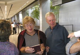 Peg & Roland inspect Maggie's passport